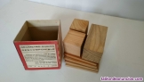 Decímetro cúbico descomponible de madera, en caja de cartón abierta por arriba. 